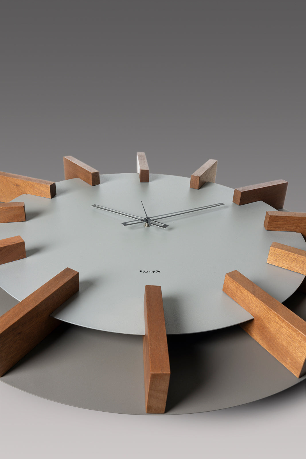 Dettaglio orologio da parete Timon Arti&Mestieri finitura fango/alluminio con indici in faggio