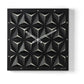 Orologio da parete Wallpape nero/avorio dal carattere moderno e originale, con struttura scatolare in ferro e superficie decorata con tagli ispirati all'origami. Vista frontale.