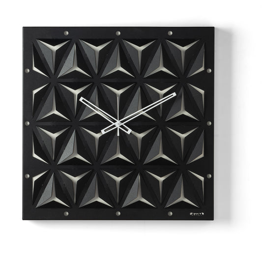 Orologio da parete Wallpape nero/avorio dal carattere moderno e originale, con struttura scatolare in ferro e superficie decorata con tagli ispirati all'origami. Vista frontale.