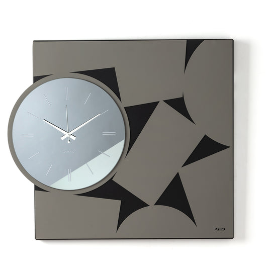 Orologio da parete Calambour, dove una struttura geometrica quadrata incontra un originale quadrante circolare in vetro specchiato. Un raffinato gioco di forme, profondità e riflessi che dona dinamismo alla parete. Vista frontale. Finitura nero/fango/fumé.