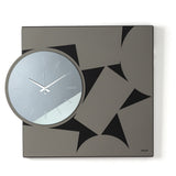 Orologio da parete Calambour, dove una struttura geometrica quadrata incontra un originale quadrante circolare in vetro specchiato. Un raffinato gioco di forme, profondità e riflessi che dona dinamismo alla parete. Vista frontale. Finitura nero/fango/fumé.