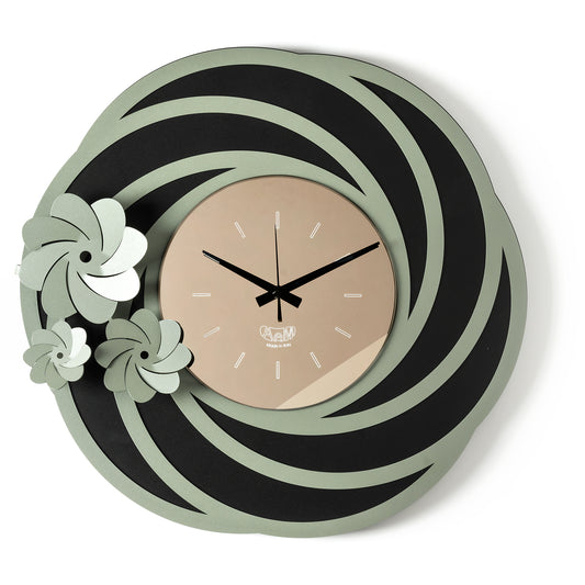Orologio da parete Tahiti dal design floreale e tridimensionale, con una struttura traforata ispirata a petali stilizzati e tre fiori di diverse dimensioni. Il quadrante in vetro specchiato completa una composizione elegante. Vista frontale. Finitura nero/giada/bronzo