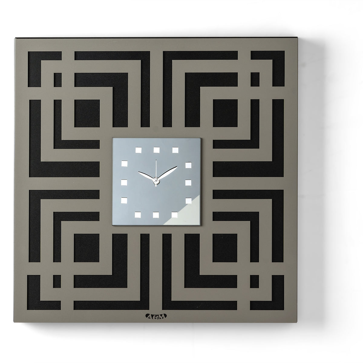 Orologio da parete Labyrinth dal design geometrico e tridimensionale, caratterizzato da un elegante motivo a labirinto traforato e da un quadrante quadrato in vetro specchiato. Indicatori in cristallo acrilico completano una composizione ricca di profondità e dettagli. Vista frontale, finitura nero/fango/fumé.