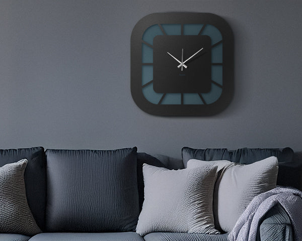 Orologio Exo di Arti&Mestieri. appeso sopra divano con cuscini. Versione adatta per mobile